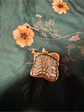 Gold Wave Glass Ornament with Green and White Accents